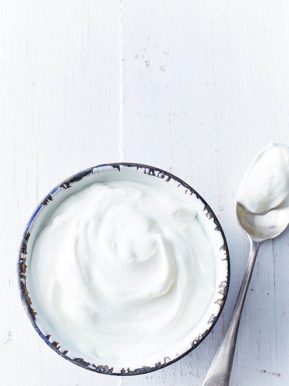 greek yogurt in a white bowl on a white wooden table