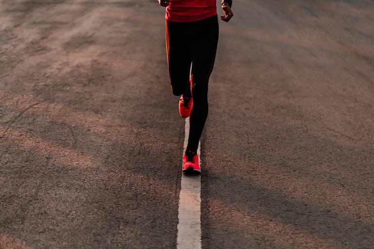 Low Section Of Athlete Running On Road