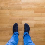 low section of man standing on hardwood floor