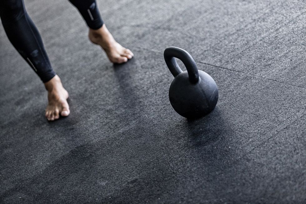 low section of man with kettlebell in gym