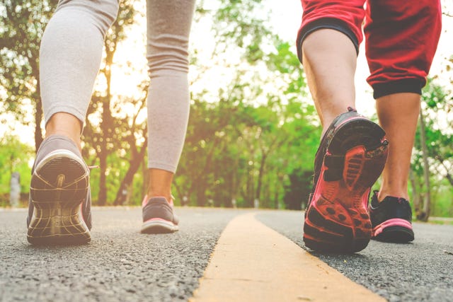 Low Section Of People Wearing Sports Clothing While Walking On Road