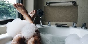 Low Section Of Woman Bathing In Bathtub