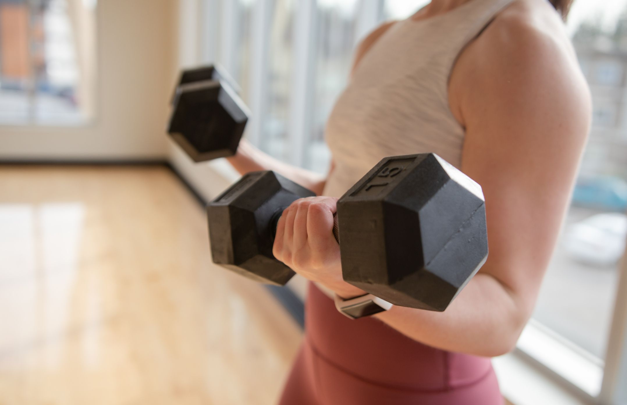 https://hips.hearstapps.com/hmg-prod/images/low-section-of-woman-exercising-with-dumbbells-at-royalty-free-image-1647548948.jpg