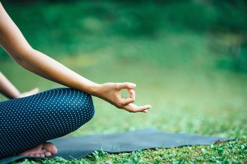 low section of woman practicing yoga in park