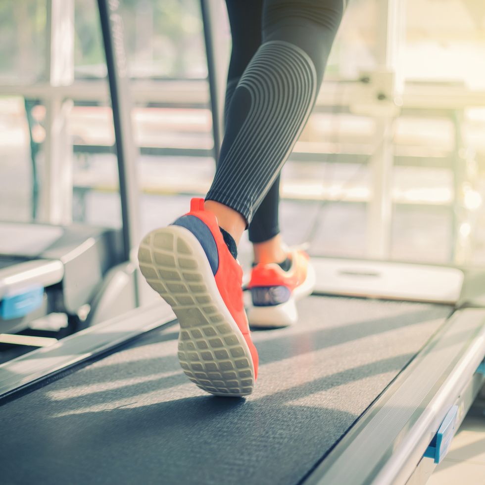 low section of woman running on treadmill in gym