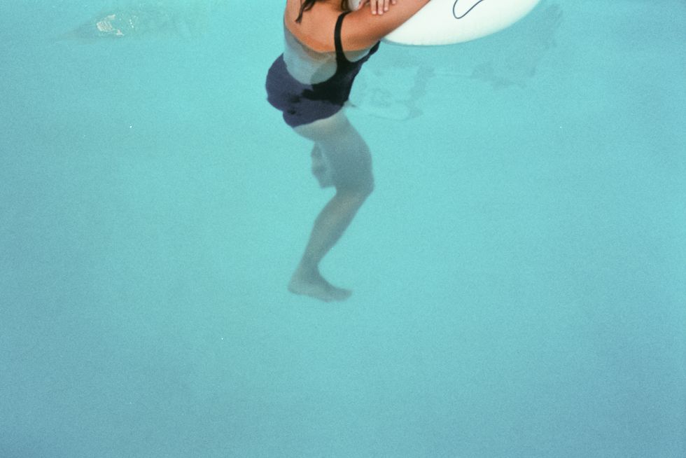 low section of woman swimming in pool