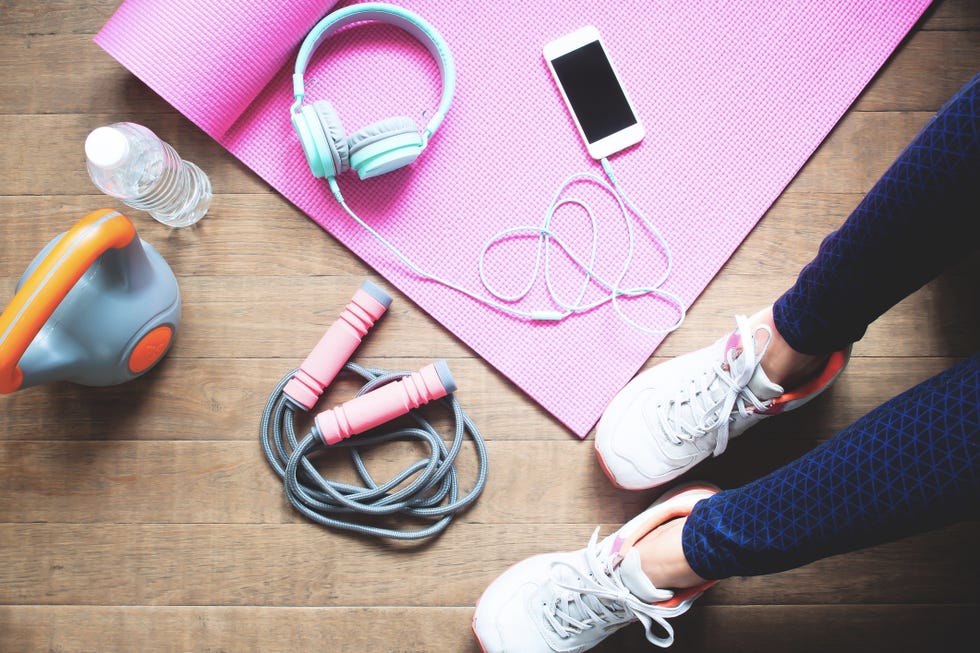 low section of woman with exercise equipment sitting on hardwood floor