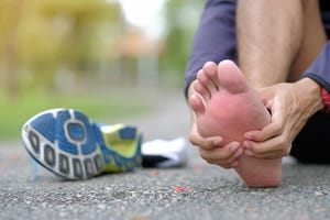 low section of young man with pain sitting on road