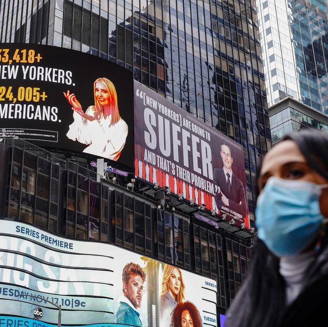 new york, united states   20201025 a woman wearing a face mask walks past a lincoln project billboard that depicts ivanka trump presenting the number of new yorkers and americans who have died of covid 19 and jared kushner next to a vanity fair quote photo by john nacionsopa imageslightrocket via getty images