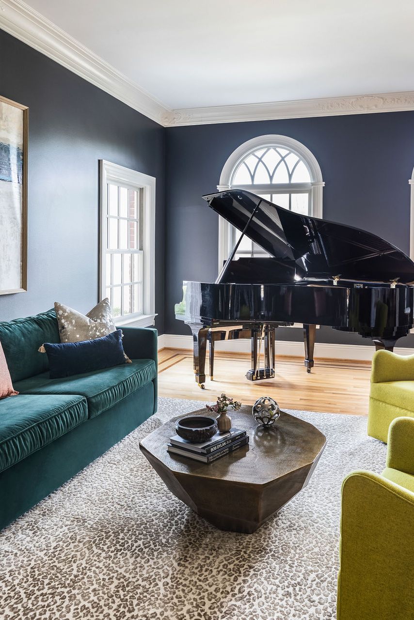 a living room with green sofa and lime green arm chairs and a black piano