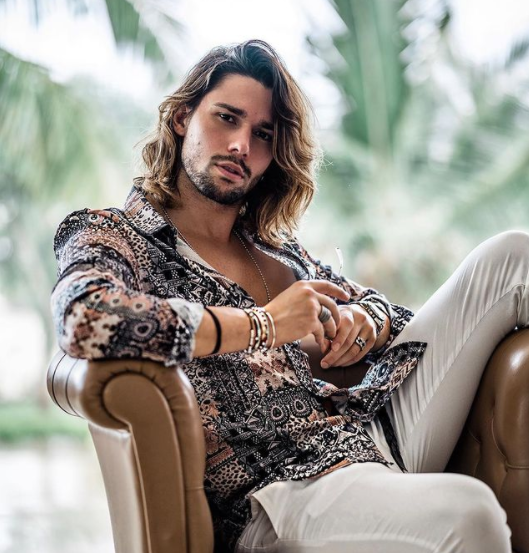 luca onestini sentado en un sofá posando