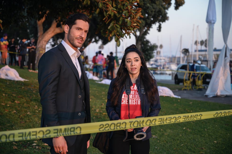 tom ellis como lucifer hablando con una chica en un parque
