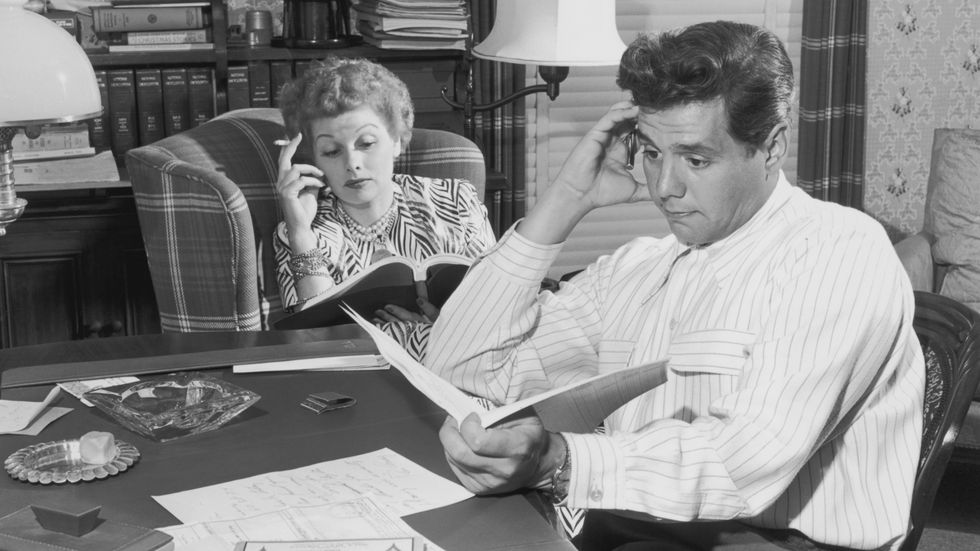 Ball And ArnazActress Lucille Ball (1911-1989) and her husband, actor Desi Arnaz (1917-1986) pictured reading at home, USA, circa 1955. Ball is also smoking a cigarette. They divorced in 1960. (Photo by Archive Photos/Getty Images)