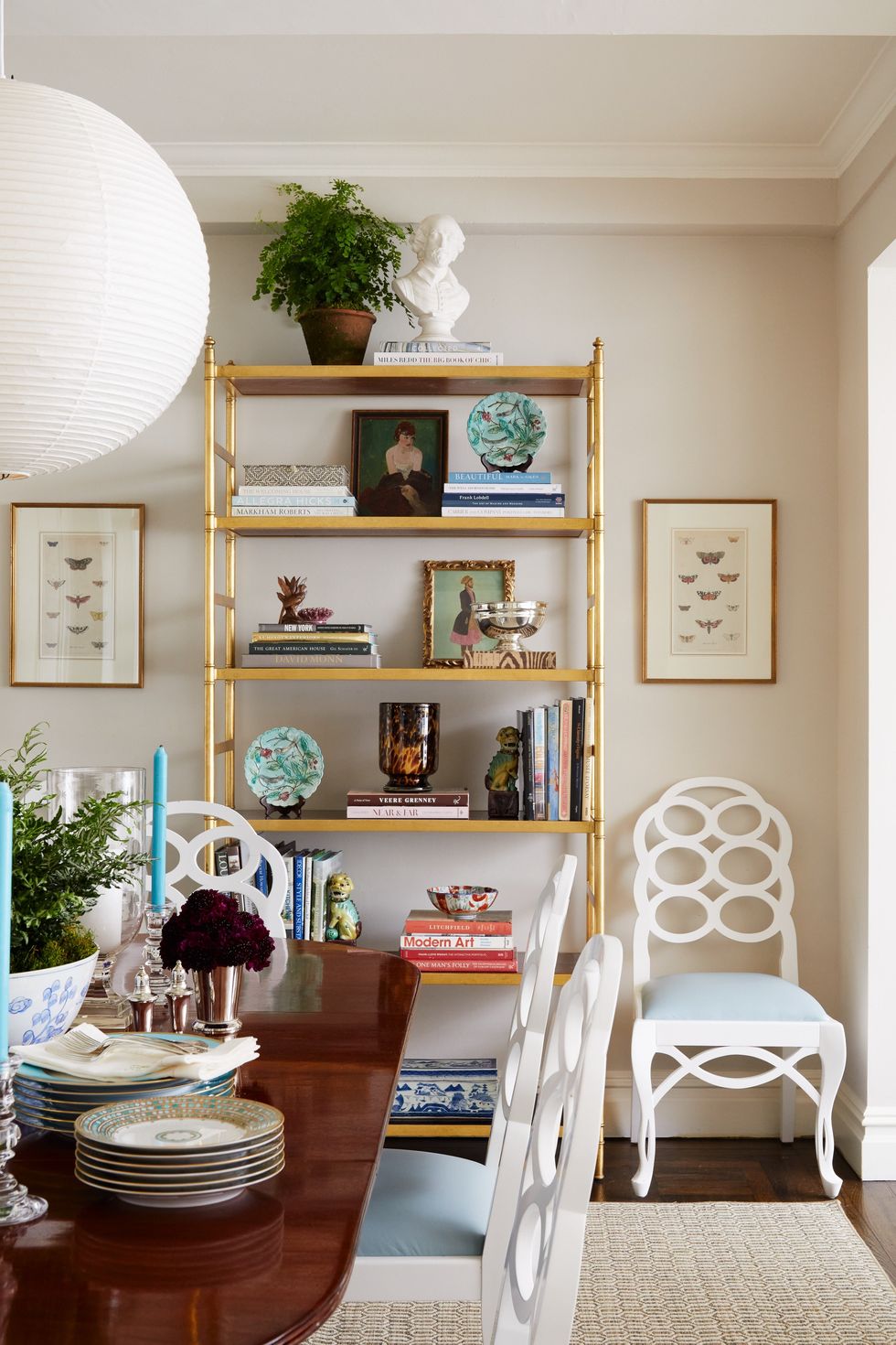 wooden dining table, white and blue chairs, gold bookcase