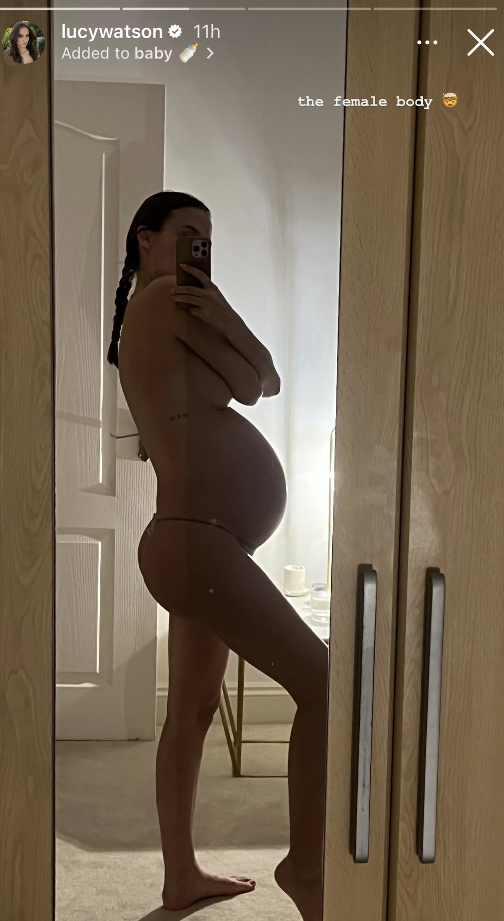 lucy takes mirror selfie from the side, with her baby bump visible