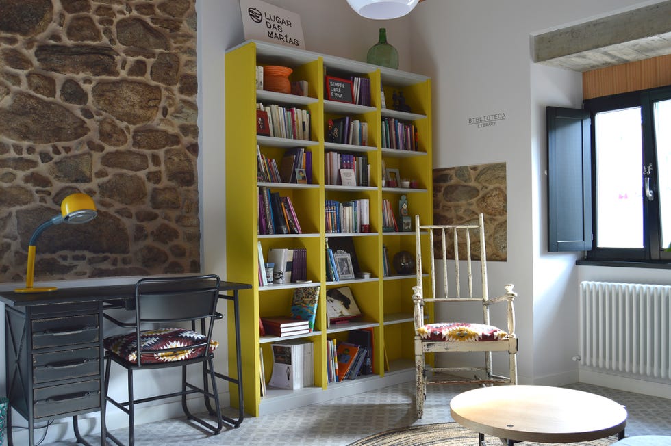 salón rústico con librería abierta y escritorio industrial