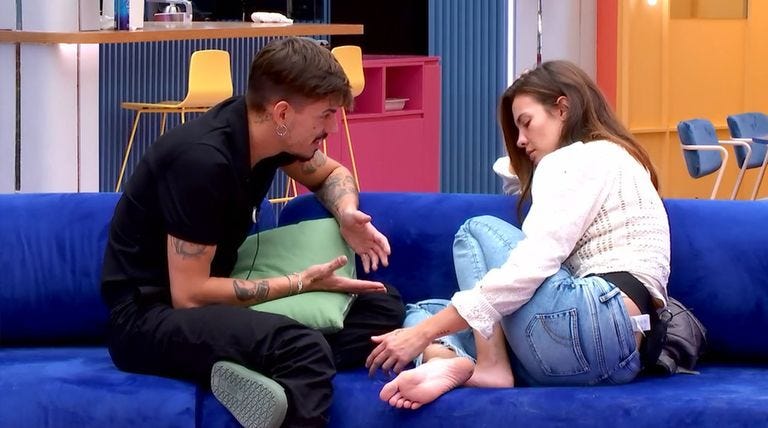 a man and a woman sitting on a blue couch