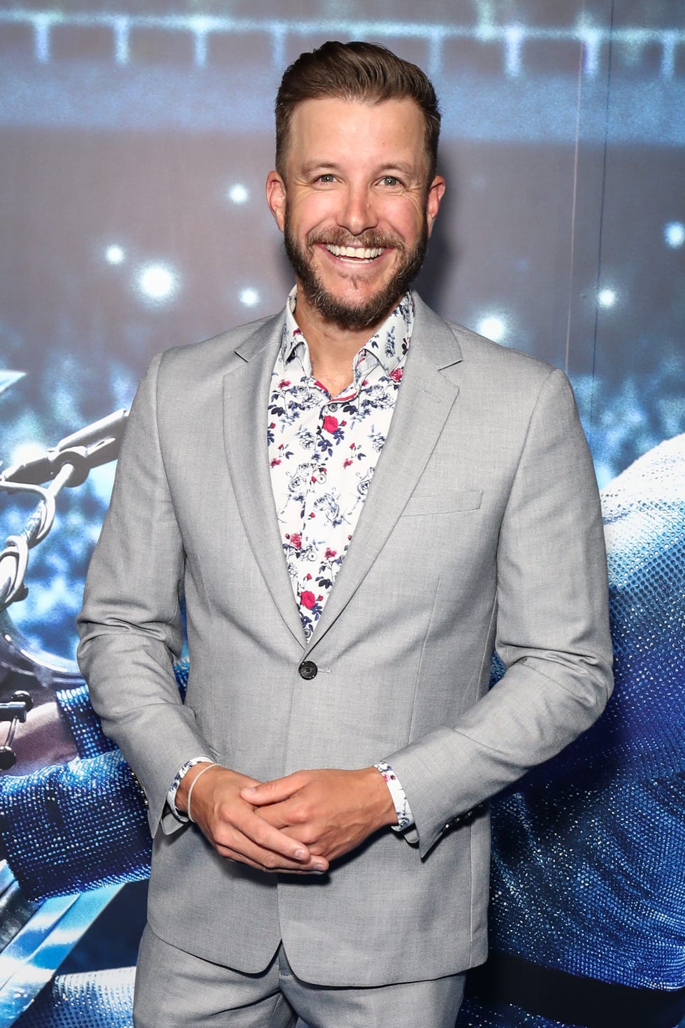luke jacobz in a grey suit and floral shirt