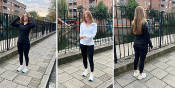 a person in athletic clothing standing near a canal with buildings in the background