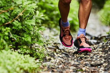 Person running on a natural trail wearing athletic shoes