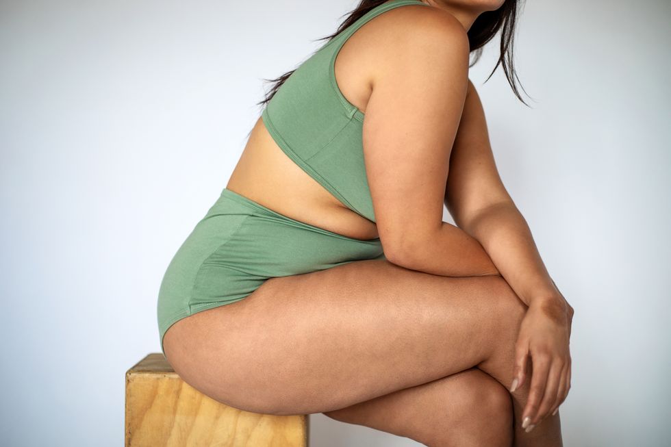 woman sat on a stool wearing green underwear