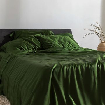 a green bed with a green comforter