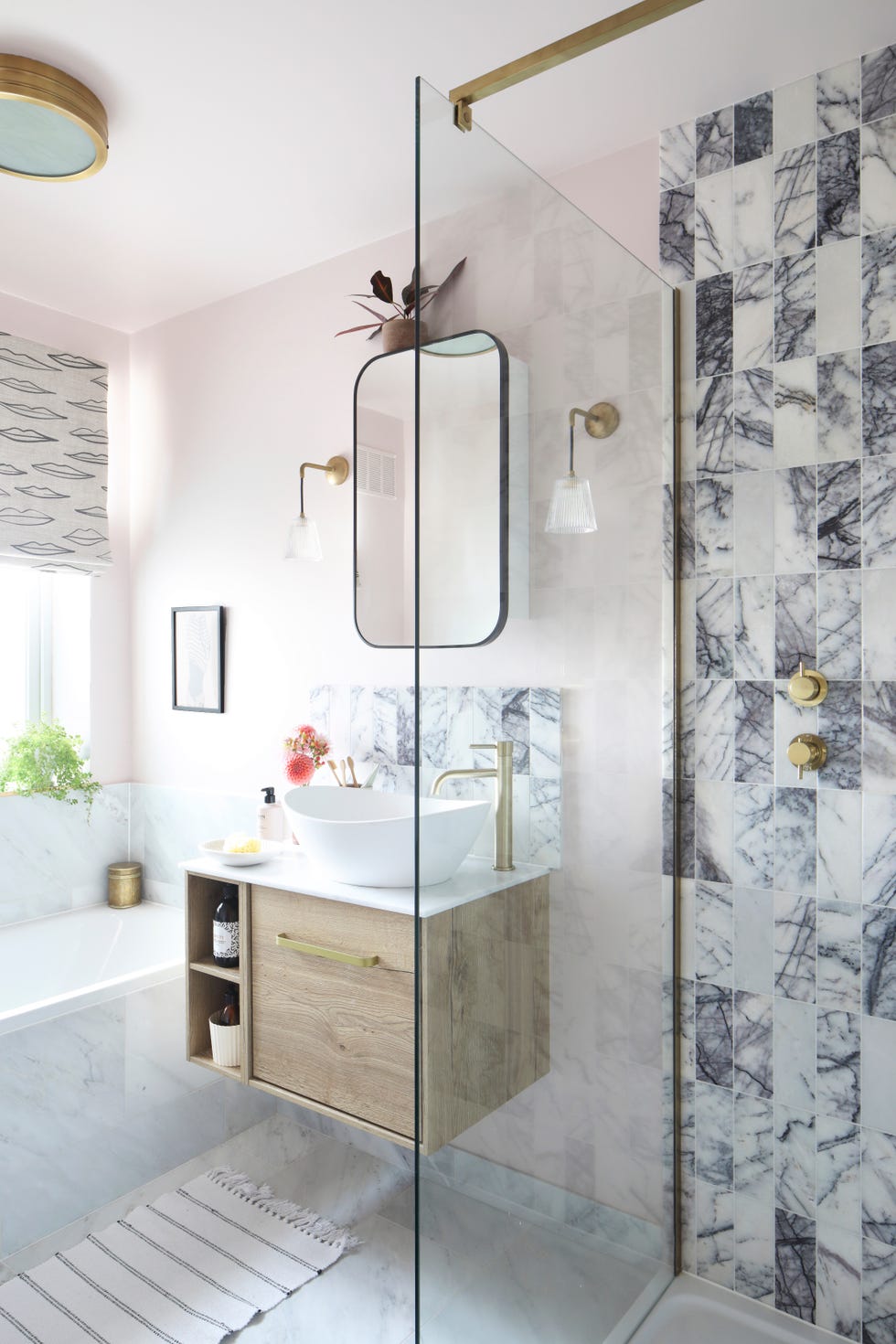 a family bathroom in a neutral colour palette featuring brass hardware and veined marble tiles
