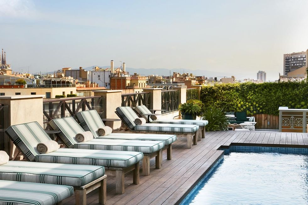 a rooftop pool with lounge chairs around it