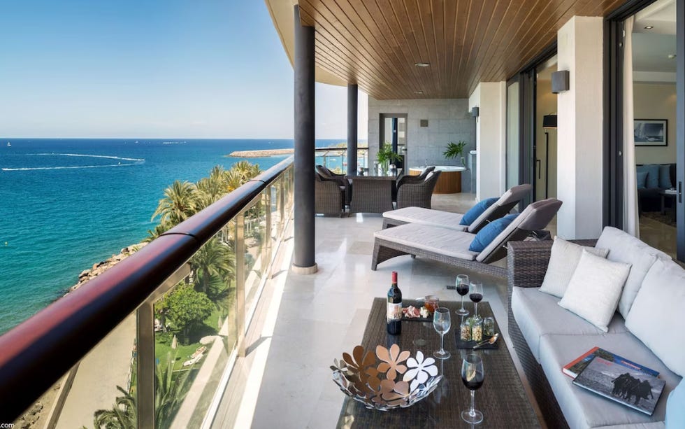 a balcony with a table and chairs overlooking the sea at blu resort