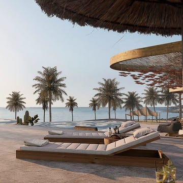 Luxury Gran Canaria Hotels - Santa Catalina a Royal Hideaway Hotel a deck with lounge chairs and umbrellas at santa catalina a royal hideaway hotel