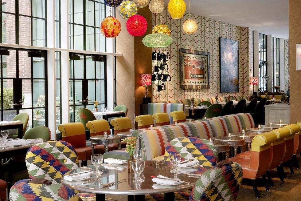 a restaurant room with colourful tables and chairs