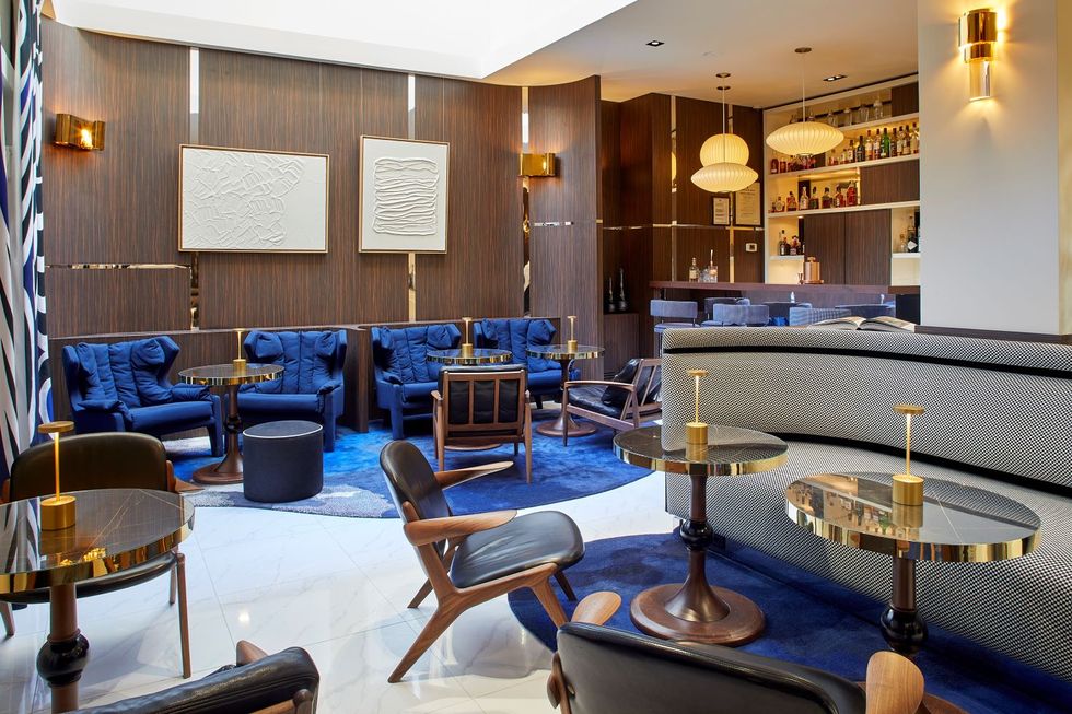 a lounge room with blue chairs and tables at hotel bel ami