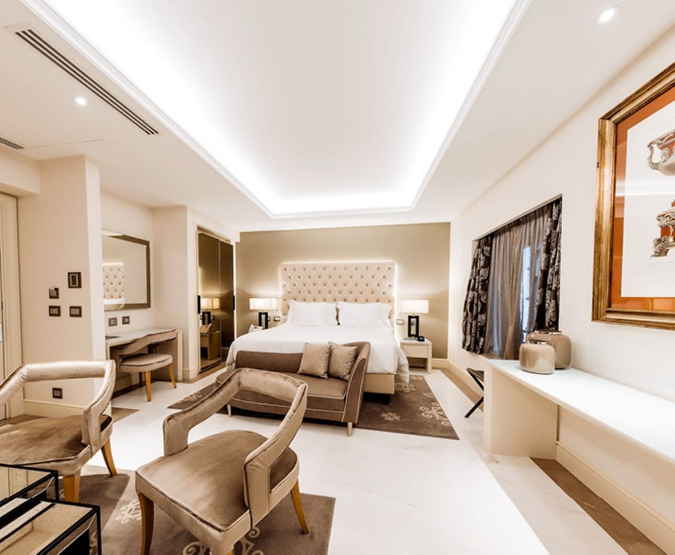 bedroom with large double bed and chairs