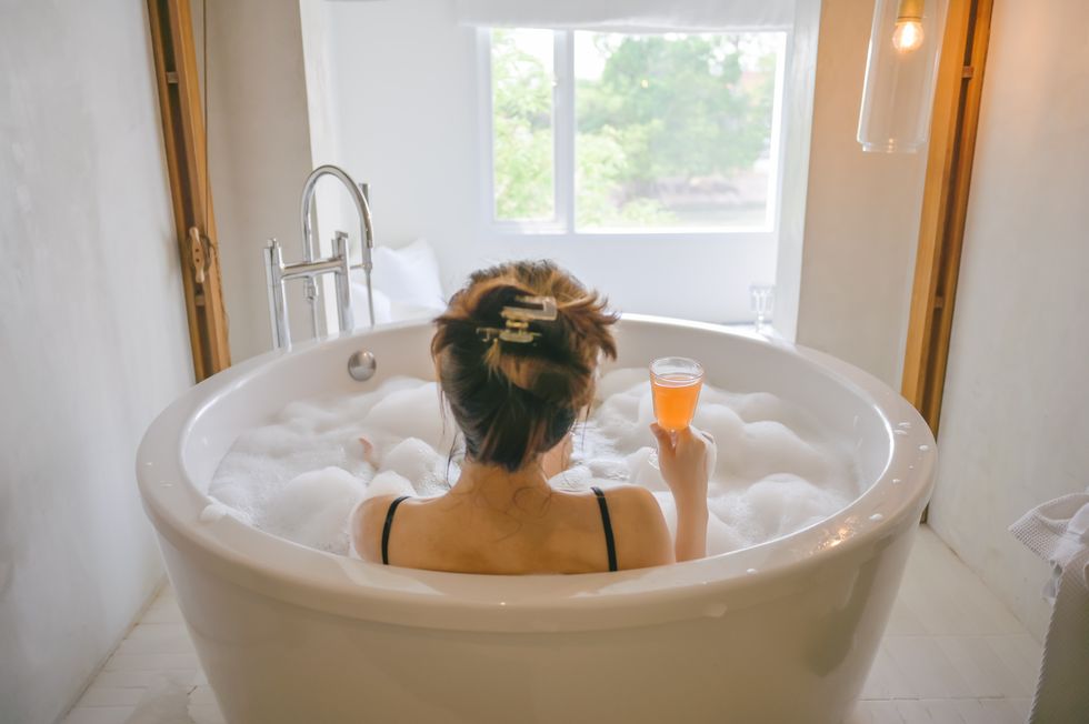 luxury lifestyle asian woman takes a bath with soap bubble in bathtub at bathroom of luxury hotel in spa while on vacation on chilling day