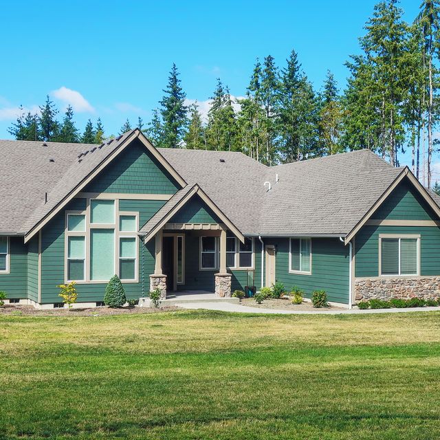luxury single story home exterior surrounded by trees