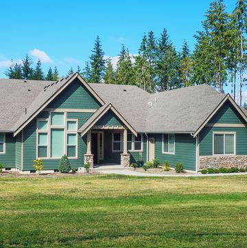 luxury single story home exterior surrounded by trees