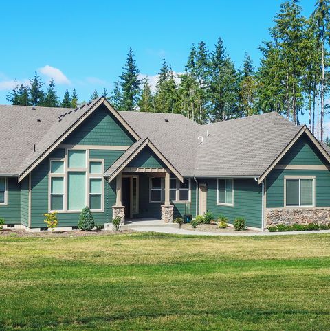luxury single story home exterior surrounded by trees