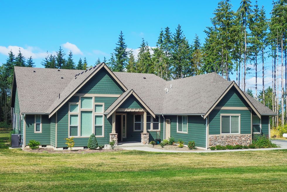 luxury single story home exterior surrounded by trees