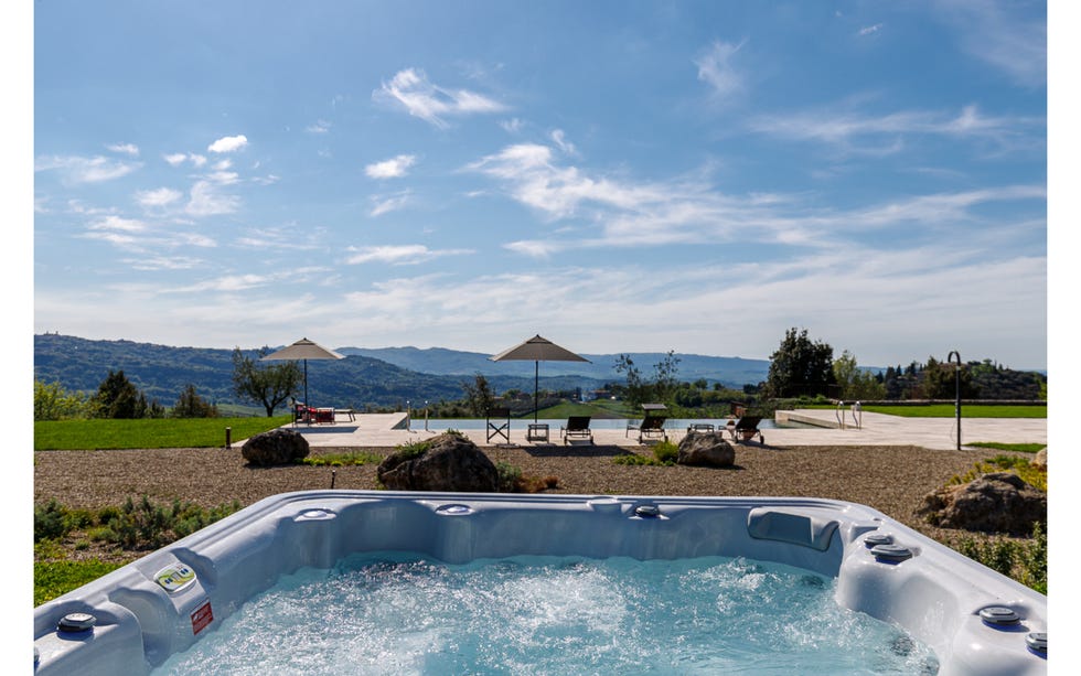 a pool with a beach and mountains in the background