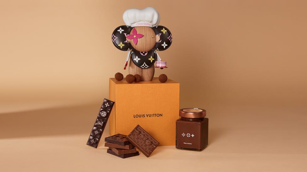 a mouse figurine with the louis vuitton logo surrounded by chocolate