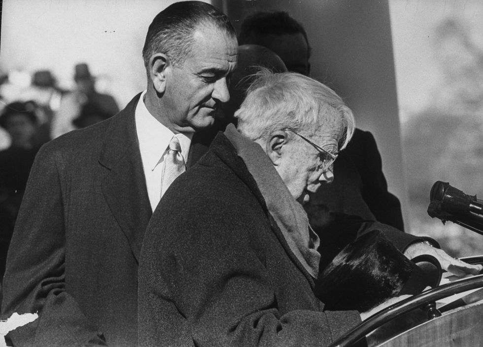 Lyndon B. Johnson assisting poet Robert Frost during the Inaugural ceremony for President John F. Kennedy