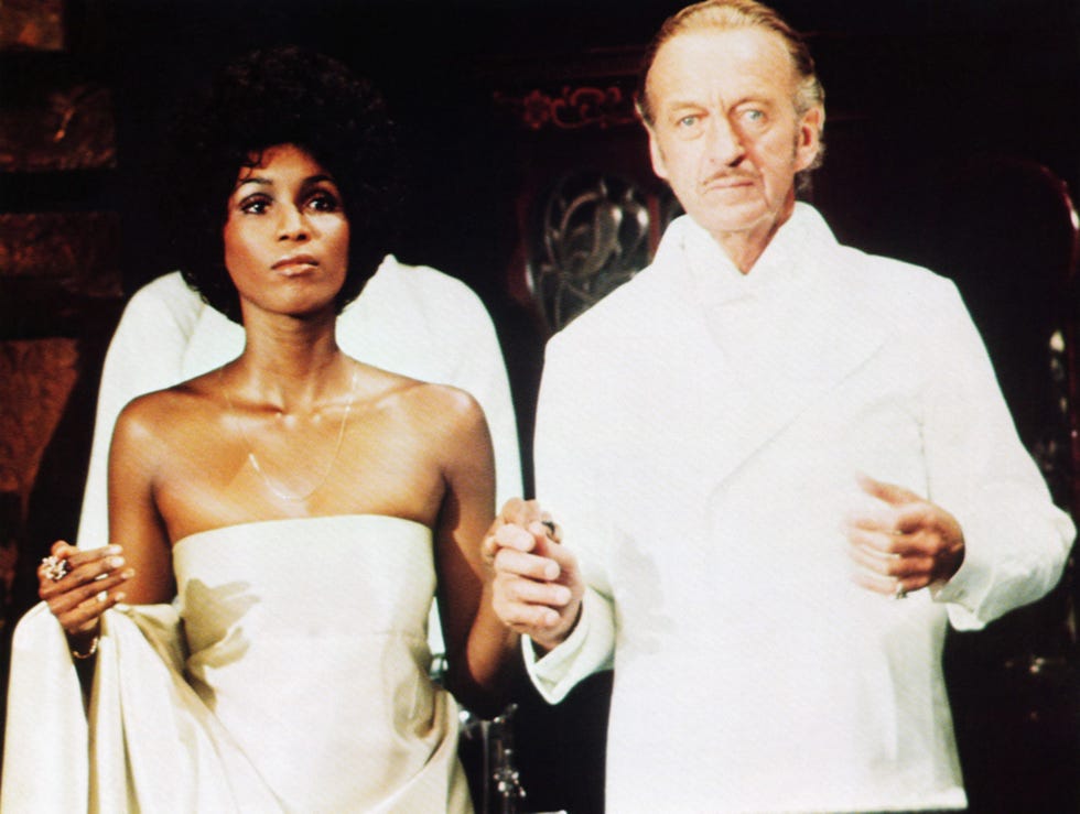 a couple dressed in formal attire holding hands