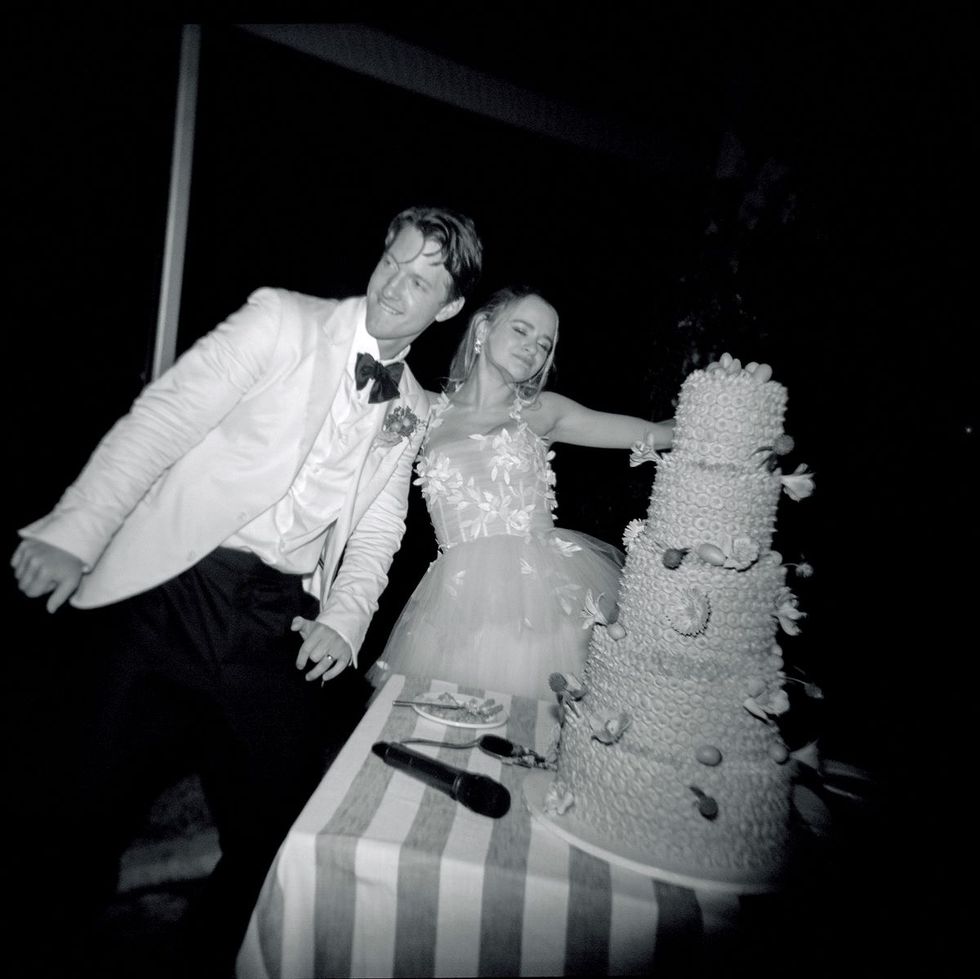 a bride and groom cutting a cake