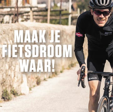 fietser in alpecin kleding beklimt berg op een racefiets