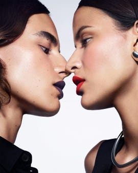 a person kissing another woman's cheek