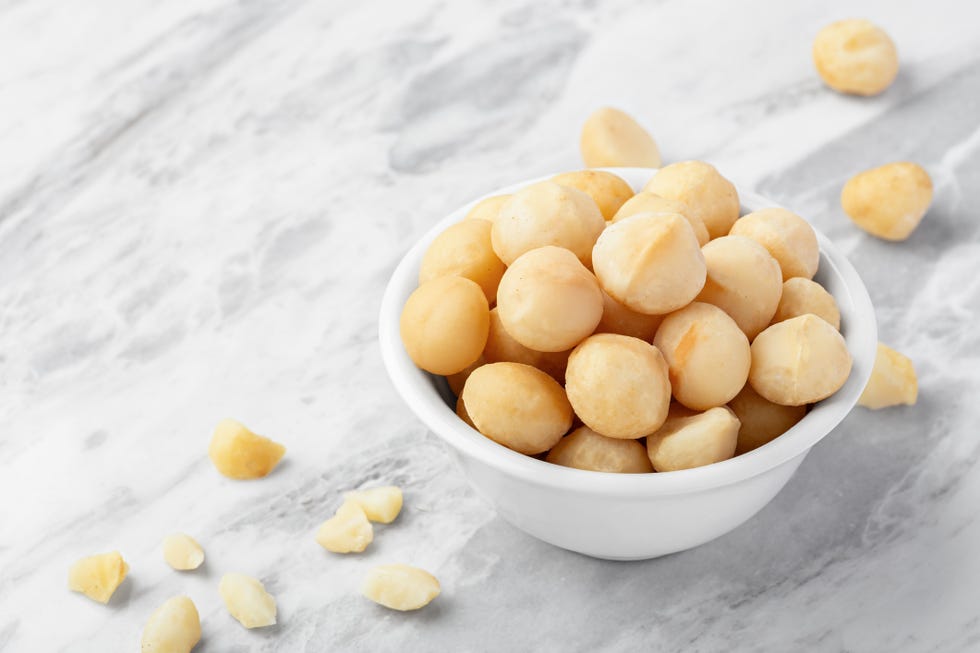 macadamia nuts in white bowl on marble kitchen counter