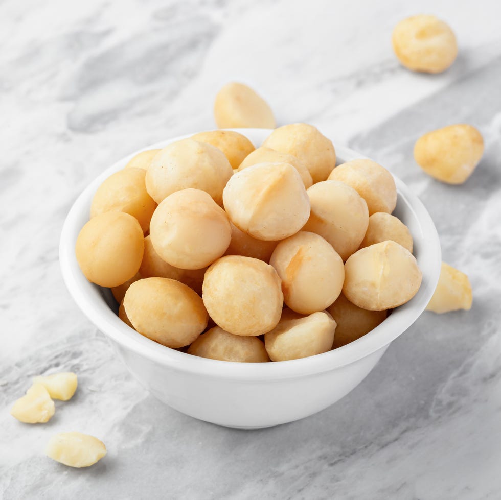 Macadamia nuts in white bowl on marble kitchen counter macadamia nuts in white bowl on marble kitchen counter