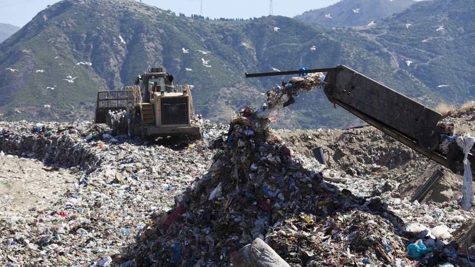 machinery dumping waste in landfill