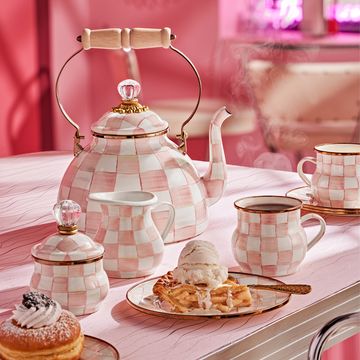a table with a plate of desserts and a teapot