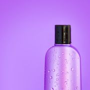 macro cosmetic purple wet bottle on a purple background horizontal copy space